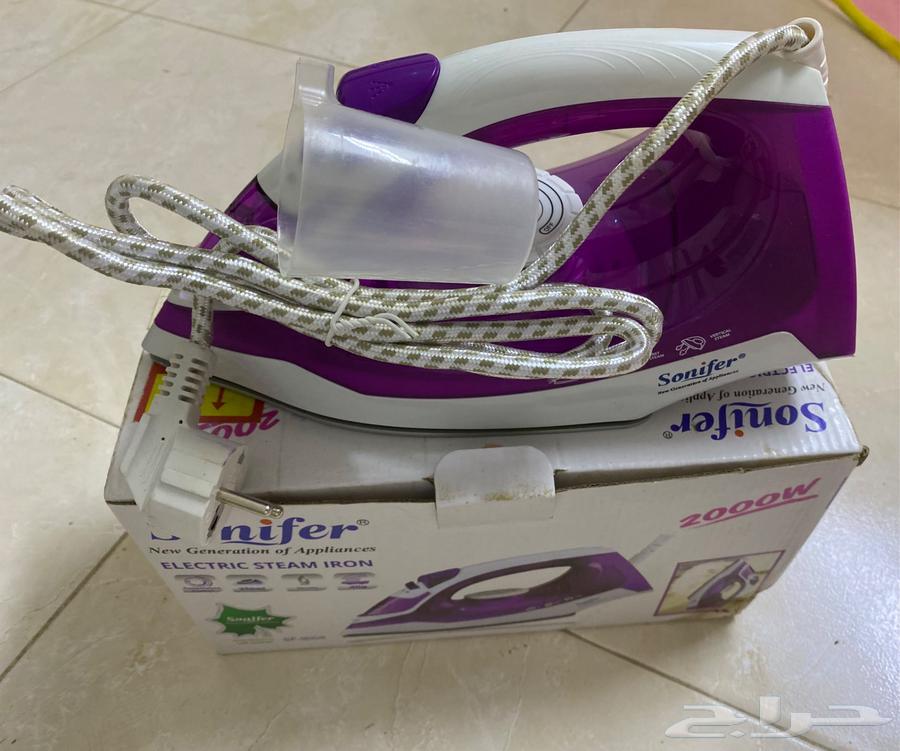A new, unused handheld steam iron in its carton.63407539557378114
